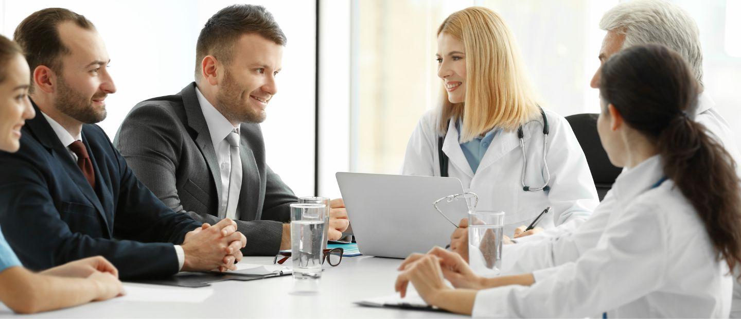 Healthcare professionals seated in a meeting room.