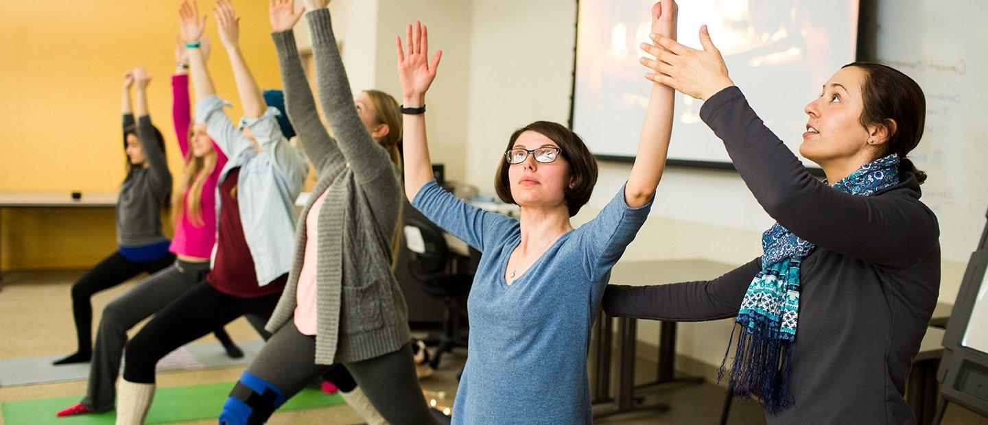 Woman leading a yoga class with five female students